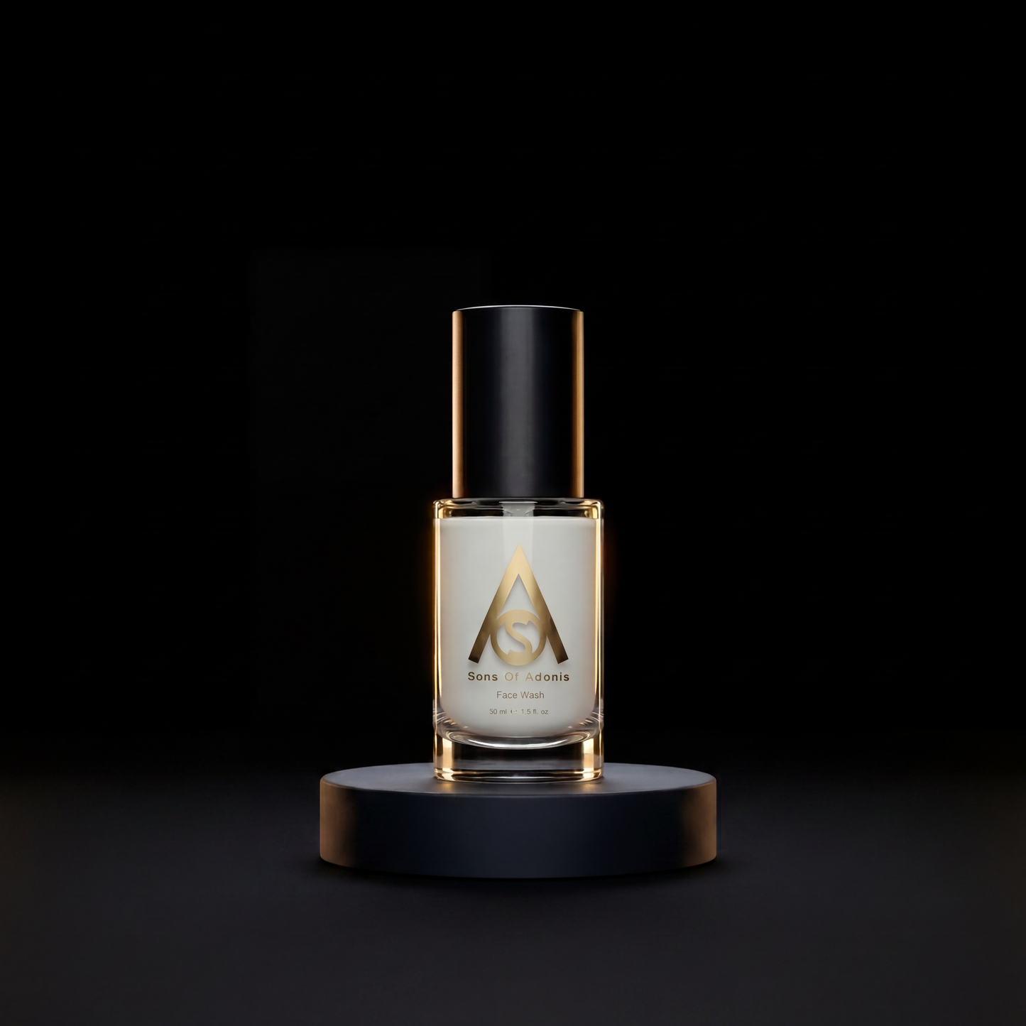 A clear glass bottle of Sons of Adonis face wash displayed on a black cylindrical pedestal against a solid black background.