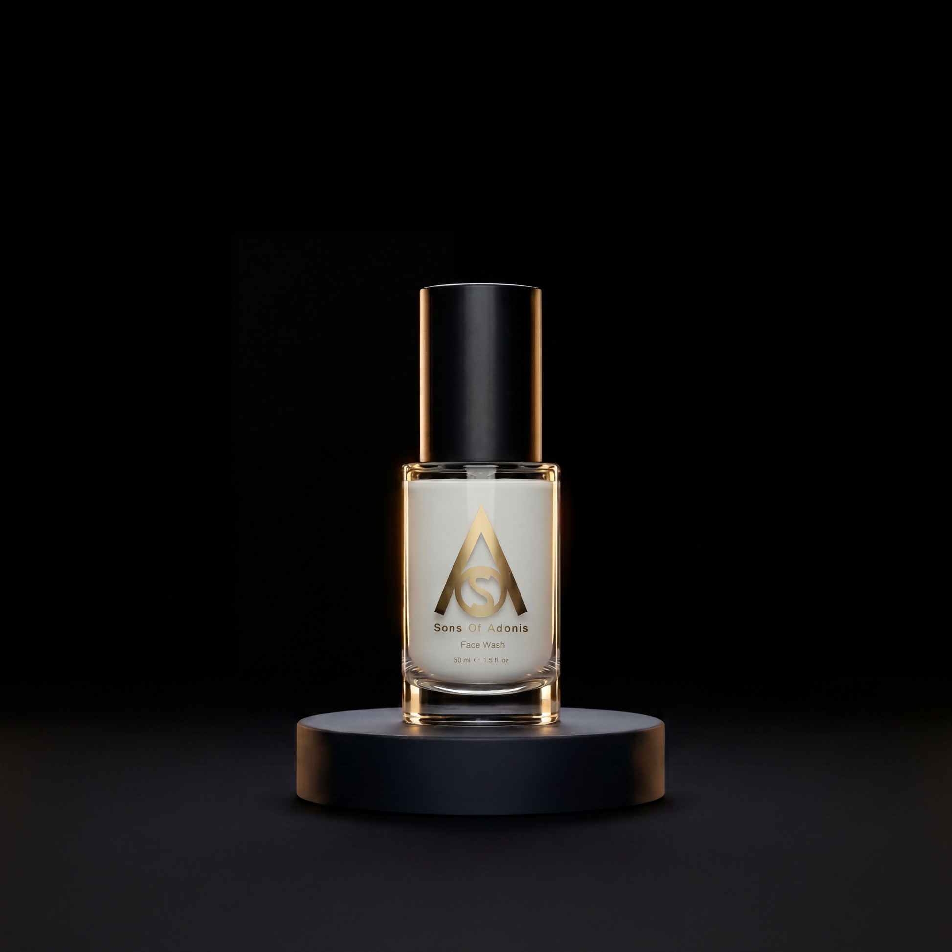 A clear glass bottle of Sons of Adonis face wash displayed on a black cylindrical pedestal against a solid black background.